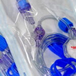 Steril verpacktes Infusionsbesteck mit Verbindungsschläuchen, Klemmen und einem Infusionsfilter für die intravenöse Verabreichung von Flüssigkeiten.