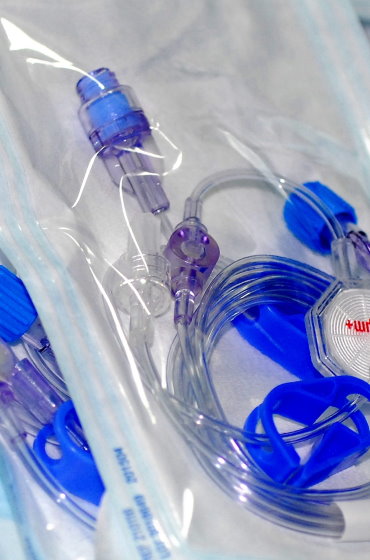 Steril verpacktes Infusionsbesteck mit Verbindungsschläuchen, Klemmen und einem Infusionsfilter für die intravenöse Verabreichung von Flüssigkeiten.