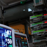 Intensivmedizinische Ausstattung: Mehrere Monitore zur Überwachung von Vitalparametern im Vordergrund und ein Turm mit Infusionsspritzenpumpen (Perfusoren) im Hintergrund.