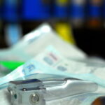 Ein steril verpackter Laryngoskop-Spatel aus Metall für die Intubation, bereitgelegt auf einer Arbeitsfläche im klinischen Bereich.