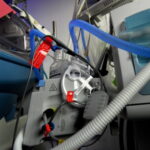 Detailaufnahme eines Atemgasbefeuchters (Fisher & Paykel) mit angeschlossenen Beatmungsschläuchen und Kabelsystemen an einem medizinischen Gerätewagen.